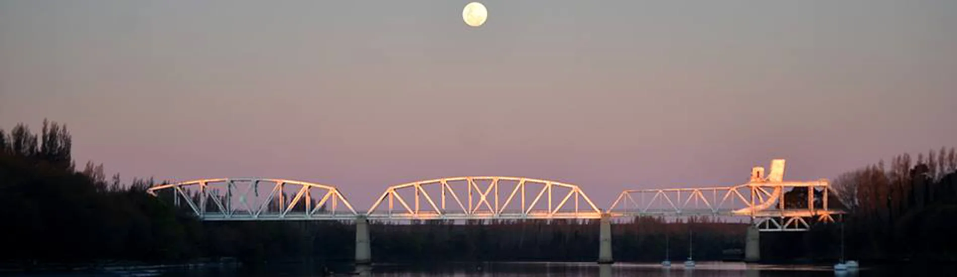 Puente ferrocarretero sobre el río al atardecer